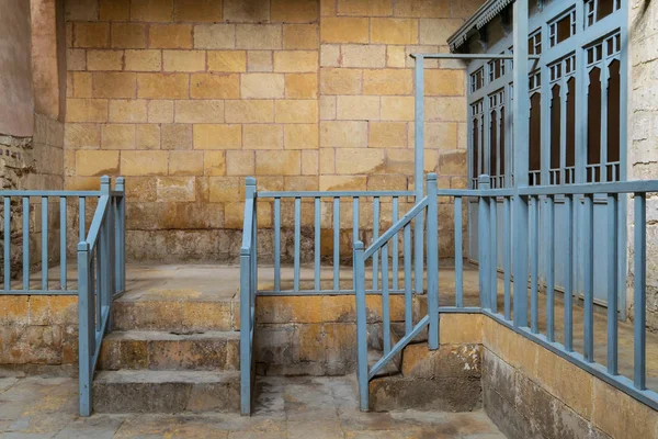 Заброшенная историческая традиционная баня с лестницей, ведущей к кирпичной каменной стене, деревянной голубой балюстраде и дверям раздевалок, Средневековый Каир, Египет — стоковое фото