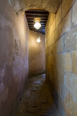 Koyu renk tuğlalı koridor ahşap tavanı klasik Arap cam sokak fenerleriyle aydınlatılmış.