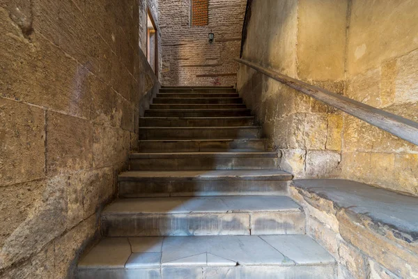 Старая узкая каменная лестница, ведущая к каменной кирпичной стене с закрытым окном — стоковое фото