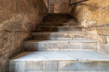 Duvarı tuğlalarla kaplı eski, dar bir merdiven.