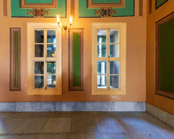 Pared naranja con ventana de madera con persianas verdes, marcos verdes rectangulares y suelo de mármol blanco —  Fotos de Stock
