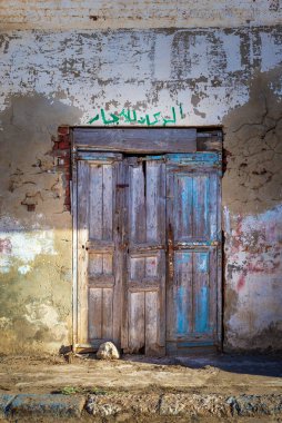 Kapalı terk edilmiş ahşap kapı ve eski püskü grunge duvar