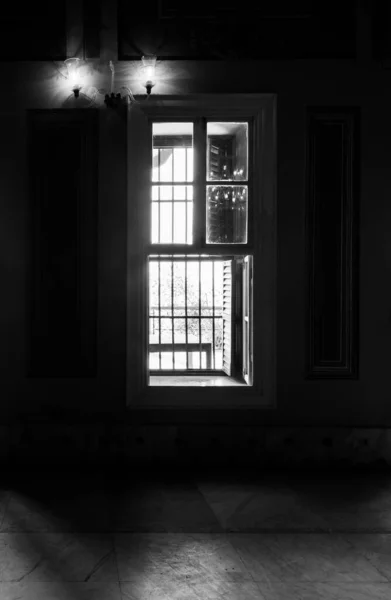 Black and white of narrow windows, revealing strong light into dark room with tiled marble floor — Stock Photo, Image