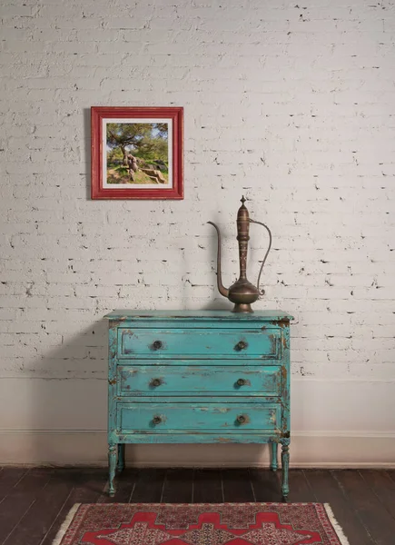 Muro de ladrillo blanco y olla de té de cobre antiguo en gabinete de turquesa vintage y pintura colgada — Foto de Stock