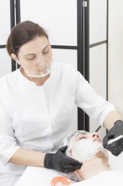 Güzellik salonunda bir adam için yaşlanmayı önleyen beyaz çamur maskesi..