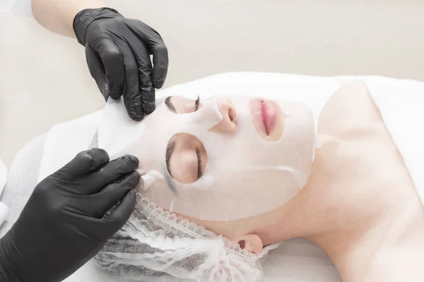 The procedure is a cleansing restorative wet mask for men in a beauty salon.