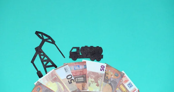A fuel truck is driving against the background of the euro to an oil platform.