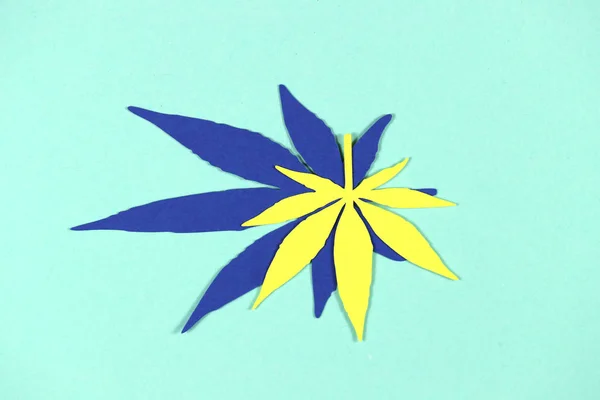 Paper applique paper hemp leaves on colored backgrounds. The concept of legalization.