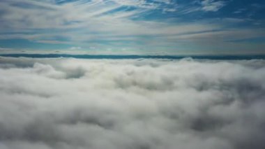 Büyük bir manzarayla bulutların üzerinde uçuyor.