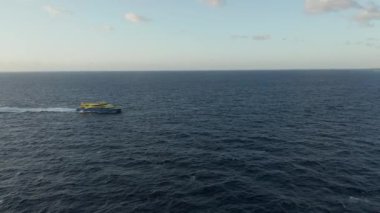 Mavi ve Sarı bir tekne Horizon 'u geçerken Hava Sabit Duruyor