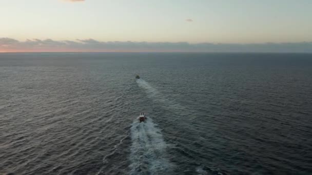 Filmagem aérea se movendo através de dois barcos para o mar ao nascer do sol — Vídeo de Stock