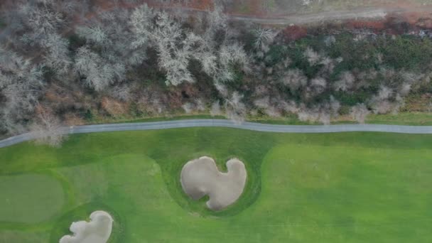 4k Aerial View Along the Border of a Golf Course next to Green Brown Trees — Stock Video