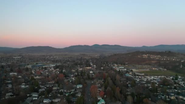 4k Εναέρια Πετώντας πάνω από την πόλη με εκπληκτική βουνά ως φόντο στο ηλιοβασίλεμα — Αρχείο Βίντεο