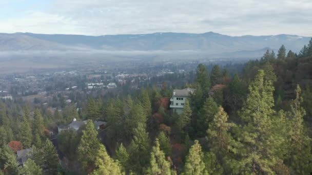 4k Aerial Moving Back Over Trees Focusing on a House on Hill in Ashland Oregon — стокове відео