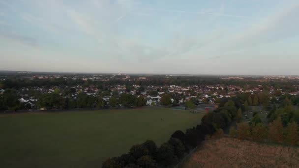 4k Hava Görüntüsü Gündoğumunda Londra 'nın banliyölerine doğru Yeşil Alan üzerinde uçuyor — Stok video