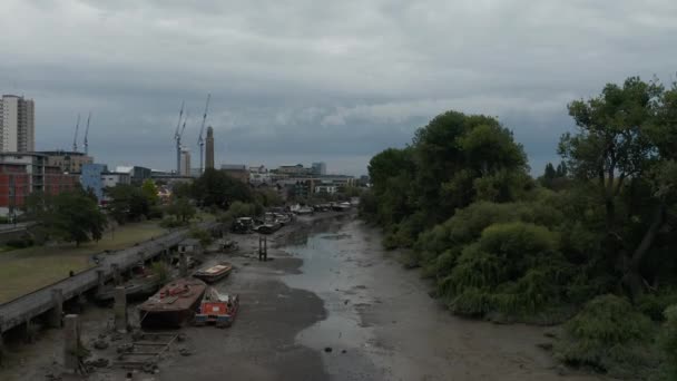 4k Aerial Shot Descendiendo al lecho del río en Londres con edificios y árboles alrededor — Vídeos de Stock