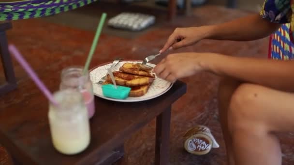 Shot τρώει ένα γαλλικό τοστ πάνω από ένα μικρό ξύλινο πάγκο στο Μεξικό — Αρχείο Βίντεο