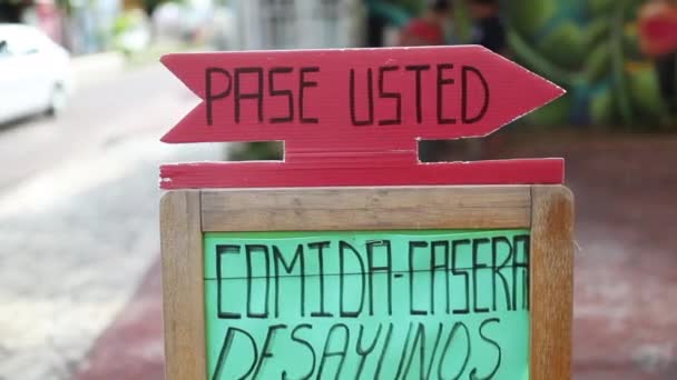 Visa en skylt med spanska ord "Pase Usted" framför en restaurang — Stockvideo