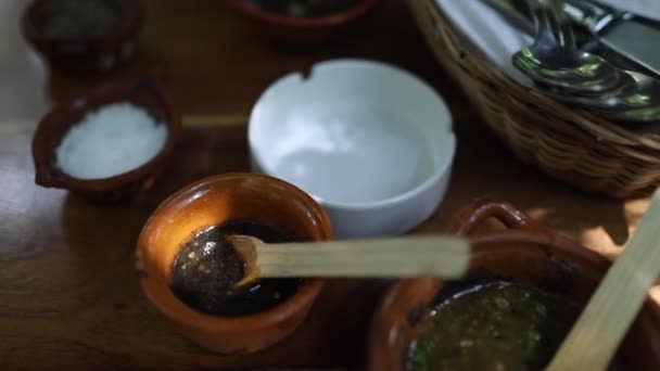 Shot σάρωσης πάνω από μεξικάνικες σάλτσες και καρυκεύματα σε ένα ξύλινο τραπέζι στο εστιατόριο — Αρχείο Βίντεο