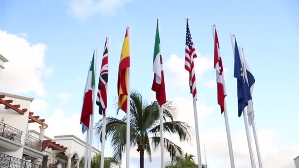 Visa av världsflaggor på ett mexikanskt hotell med vacker blå himmel i bakgrunden — Stockvideo