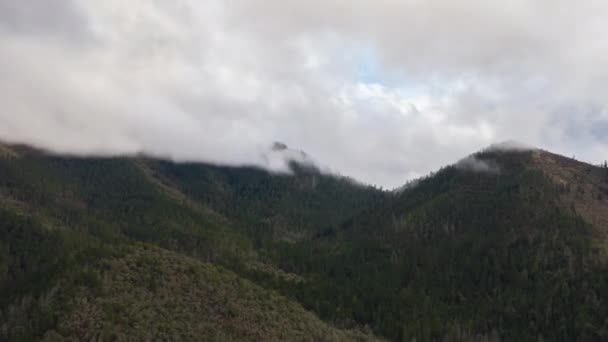 4k Timelapse aéreo do nevoeiro se movendo sobre os picos de montanhas cobertas de árvores — Vídeo de Stock