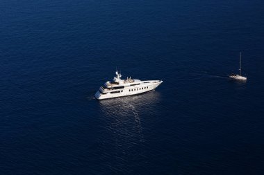 Koyu mavi bir denizde farklı boyutlarda iki beyaz deniz yatı. Yukarıdan görünüm
