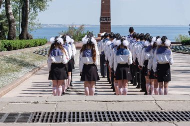 Odessa, Ukrayna, 06 Mayıs 2013: Karadeniz 'e tepeden bakan Odessa' daki bilinmeyen denizcinin anıtının önündeki meydanda duran denizci üniformalı kızlar ve oğlanlar