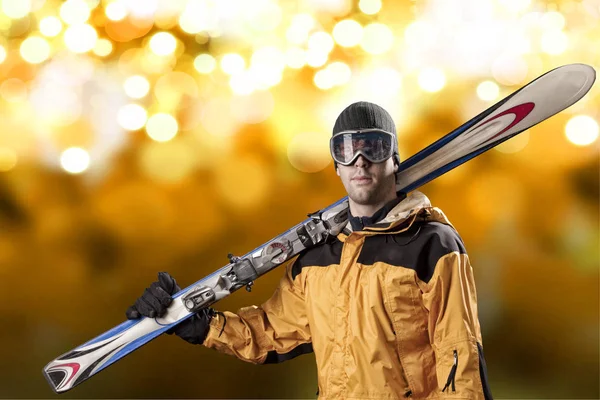 Skier holding a pair of skis — Stock Photo, Image