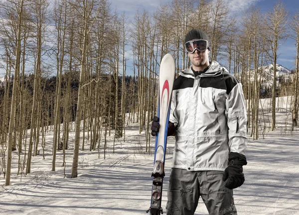 Esquiador sosteniendo un par de esquís — Foto de Stock