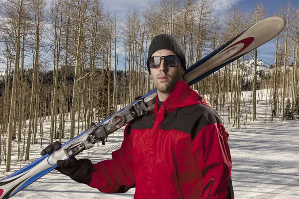 Skidåkare som håller ett par skidor — Stockfoto