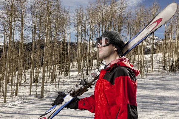 Skifahrer mit einem Paar Skier — Stockfoto