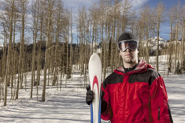 Esquiador sosteniendo un par de esquís — Foto de Stock