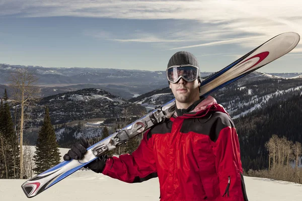 Skier holding a pair of skis — Stock Photo, Image