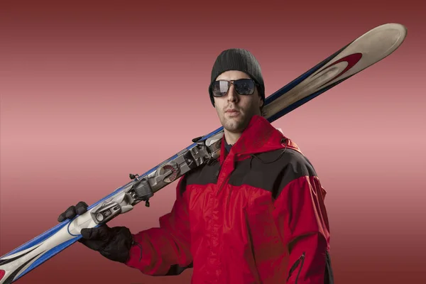 Skidåkare som håller ett par skidor — Stockfoto