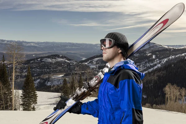 Skier holding a pair of skis — Stock Photo, Image