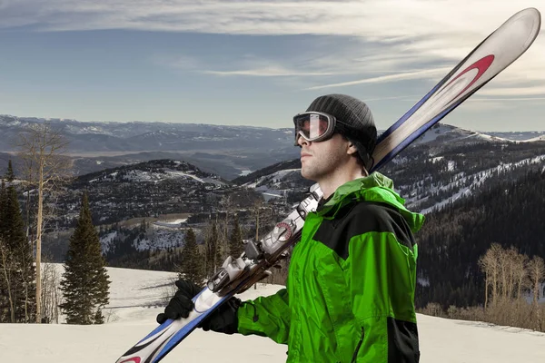 Skier holding a pair of skis — Stock Photo, Image