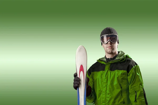 Skier holding a pair of skis — Stock Photo, Image