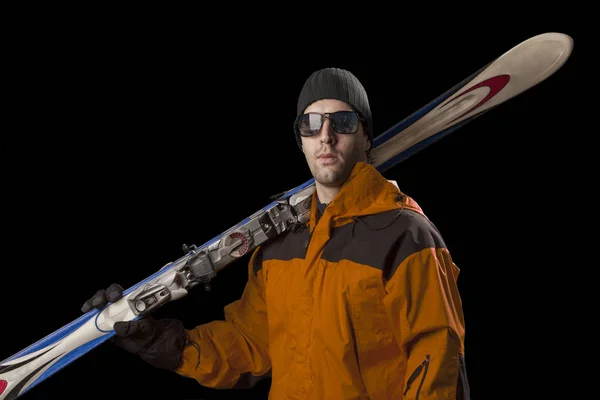 Skier holding a pair of skis — Stock Photo, Image