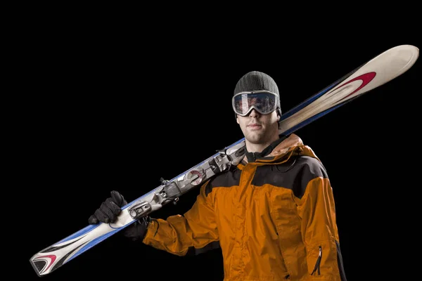 Skier holding a pair of skis — Stock Photo, Image