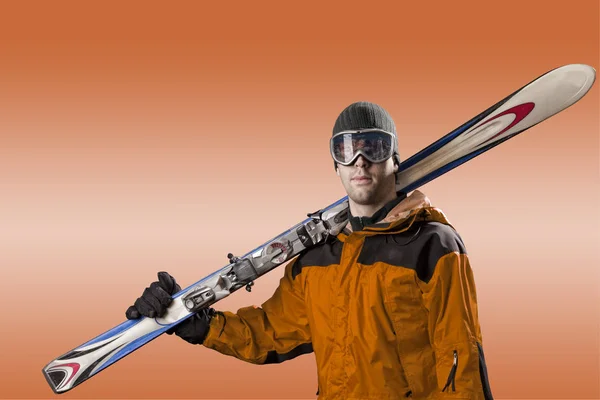 Skier holding a pair of skis — Stock Photo, Image