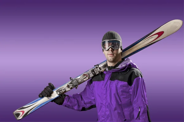 Skier holding a pair of skis — Stock Photo, Image