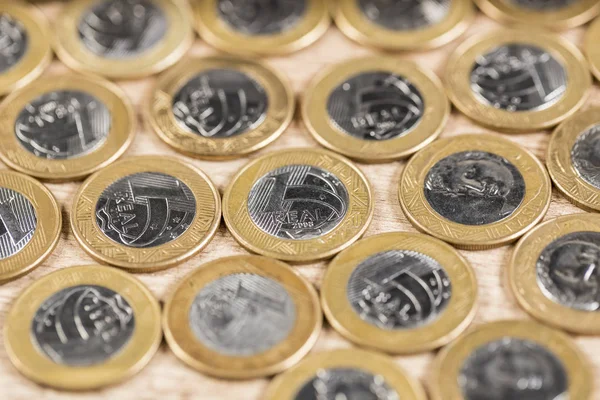 Varias 1 monedas reales en una mesa de madera — Foto de Stock
