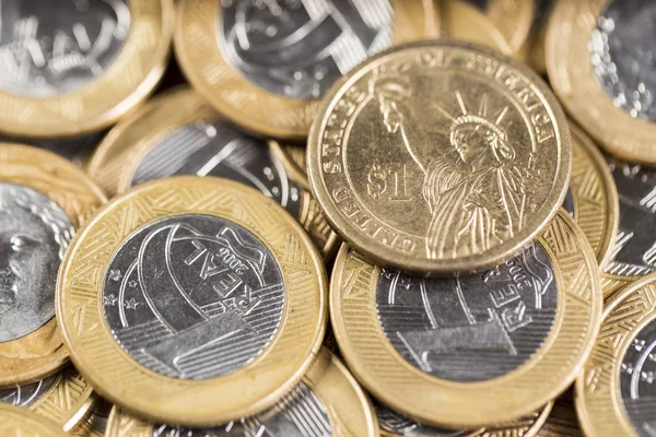 Monedas de 1 dólar en medio de varias monedas reales en una madera — Foto de Stock