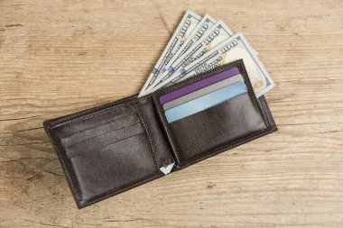 100 dolarlık Bono üzerinde ahşap bir masa ile cüzdan