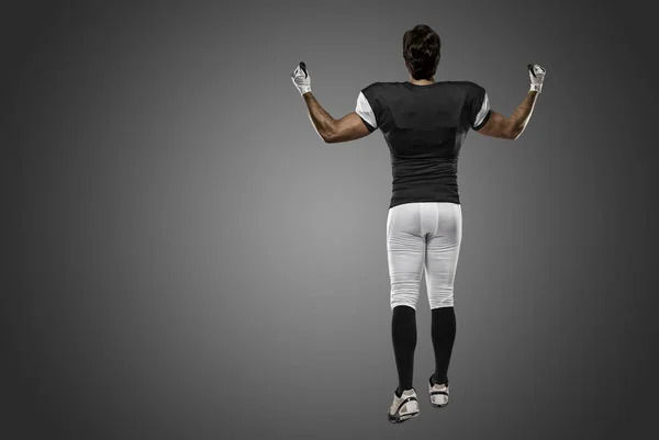 Jogador de futebol com um uniforme preto — Fotografia de Stock