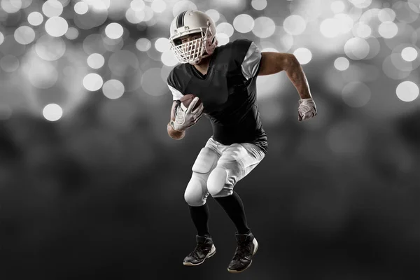 Jogador de futebol com um uniforme preto — Fotografia de Stock