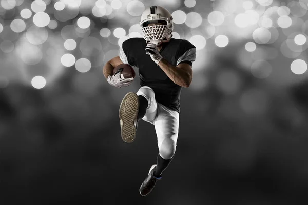 Jogador de futebol com um uniforme preto — Fotografia de Stock