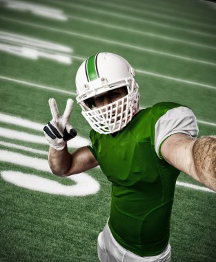 Futbolcu yeşil üniforma ile