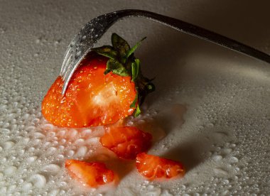 Çileği çatalla delmek su damlaları ve hafif kazayla.