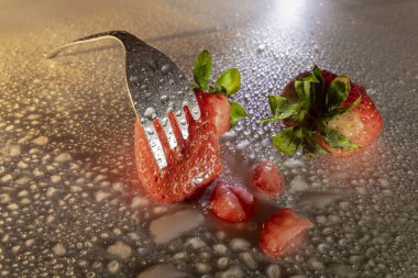 Çileği çatalla delmek su damlaları ve hafif kazayla.